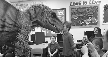 Child in the classroom with a large dinosaur